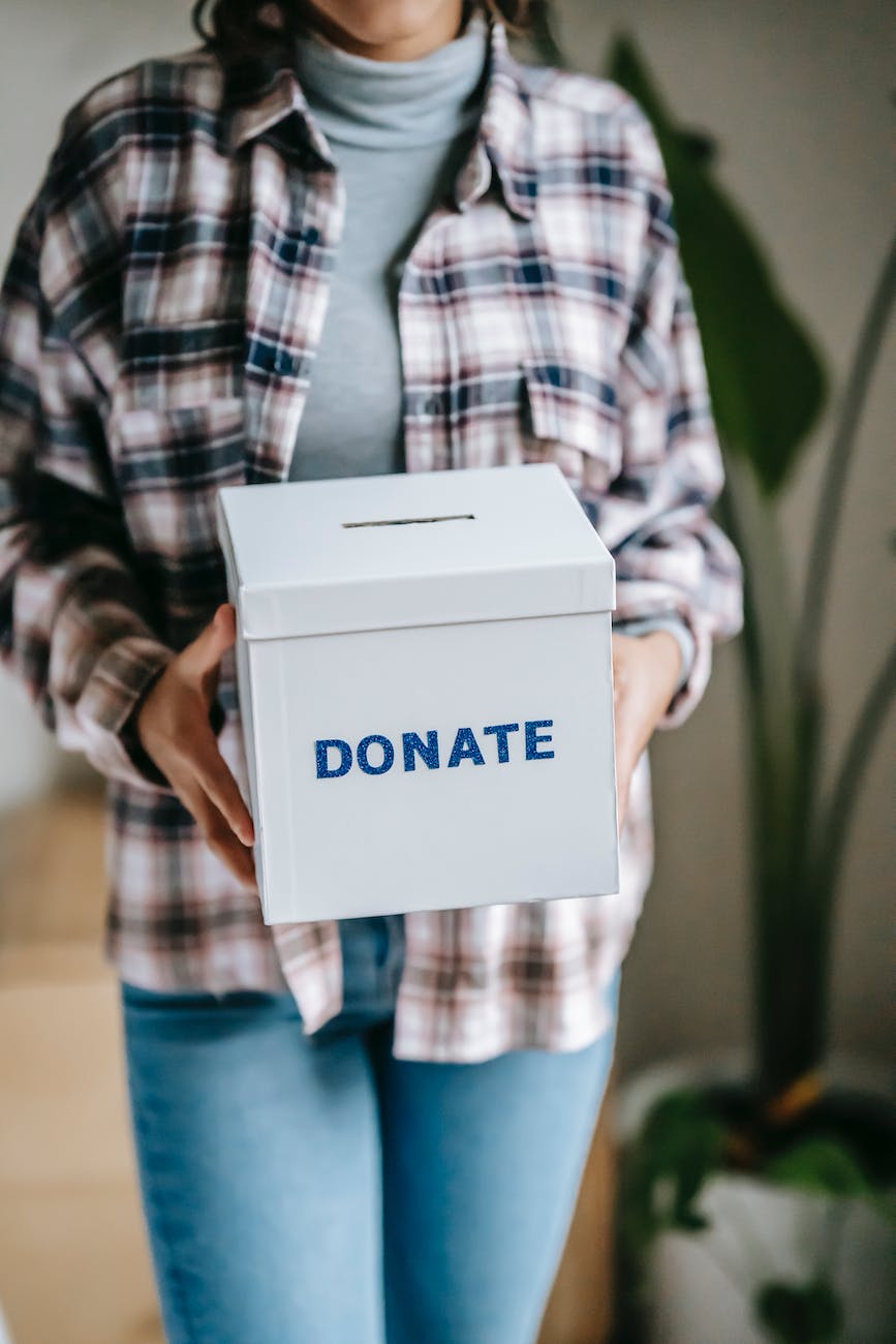 woman holding box with inscription donate in light room