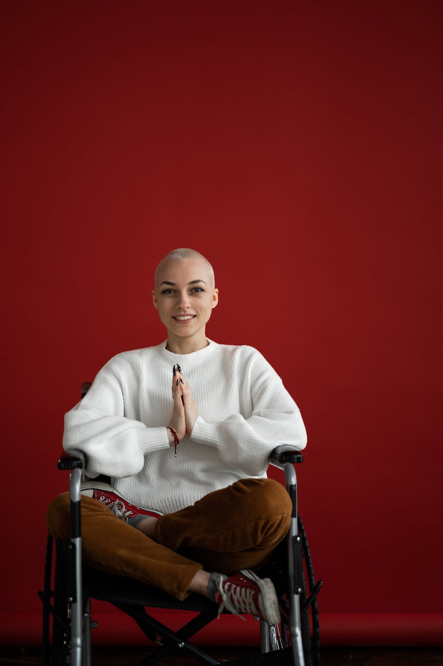 cheerful woman practicing yoga with praying hands in wheelchair